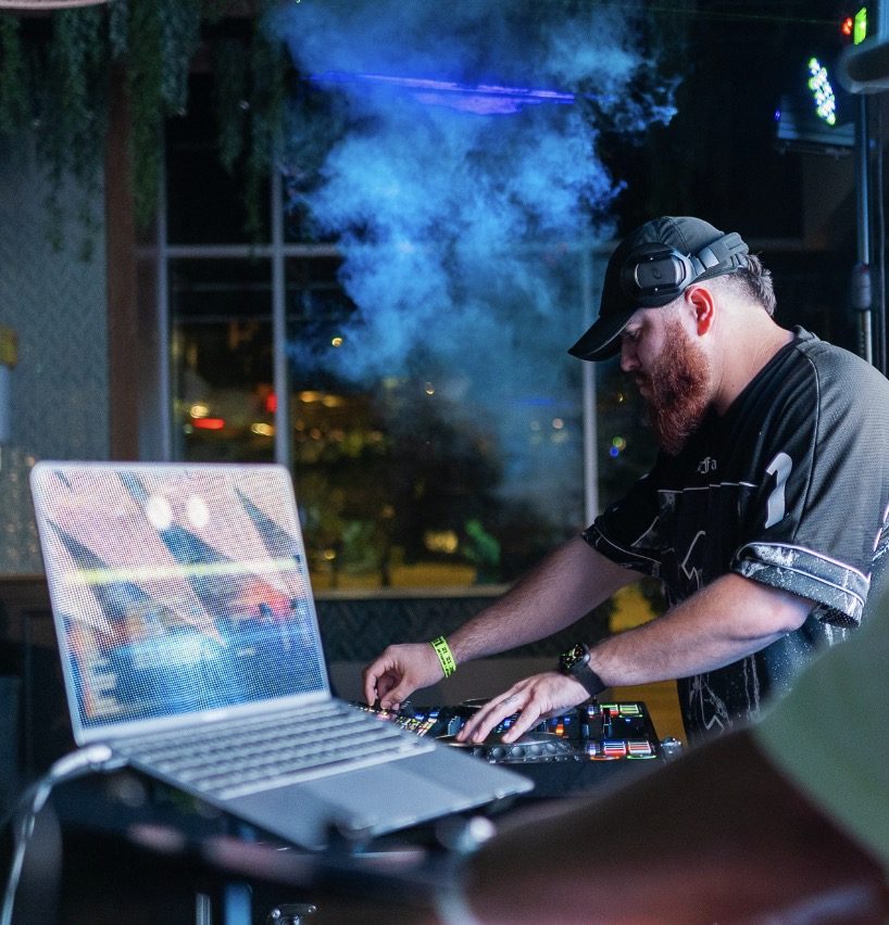 G at the decks in a number 1 jersey with blue fog and a laptop
